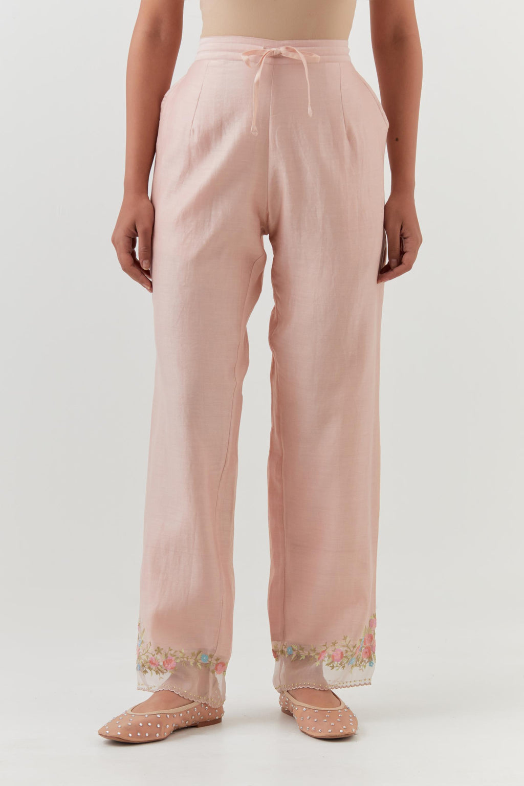 Pink silk chanderi straight pants with a broad organza scalloped hem, highlighted with embroidered rose flower bunches and beads.