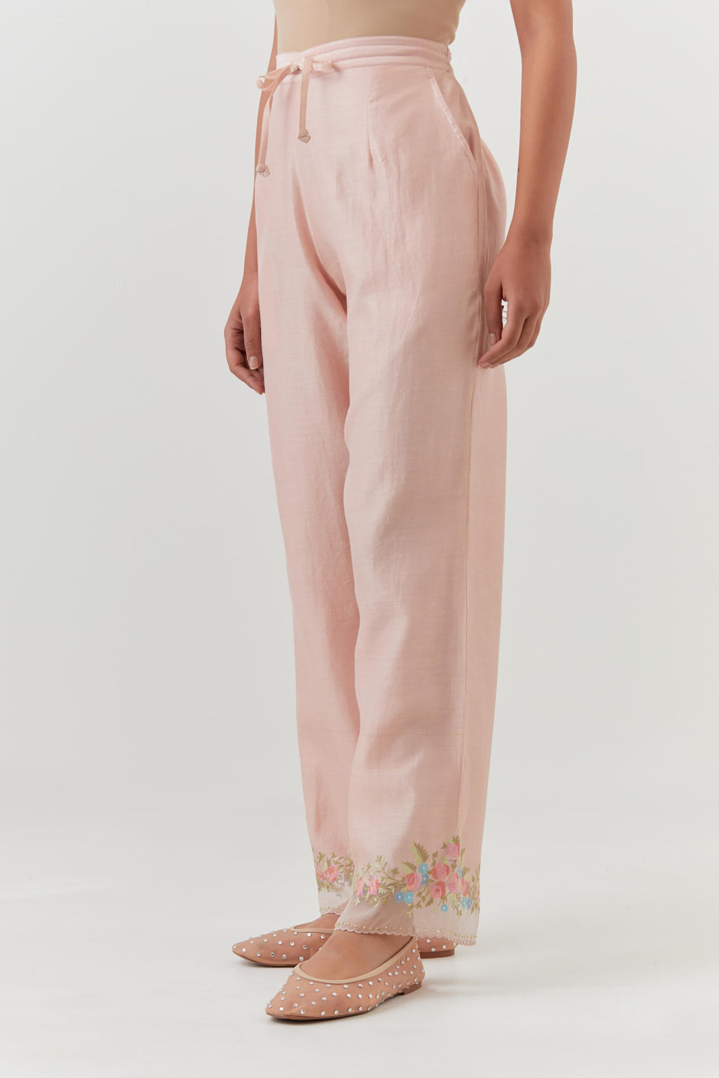 Pink silk chanderi straight pants with a broad organza scalloped hem, highlighted with embroidered rose flower bunches and beads.