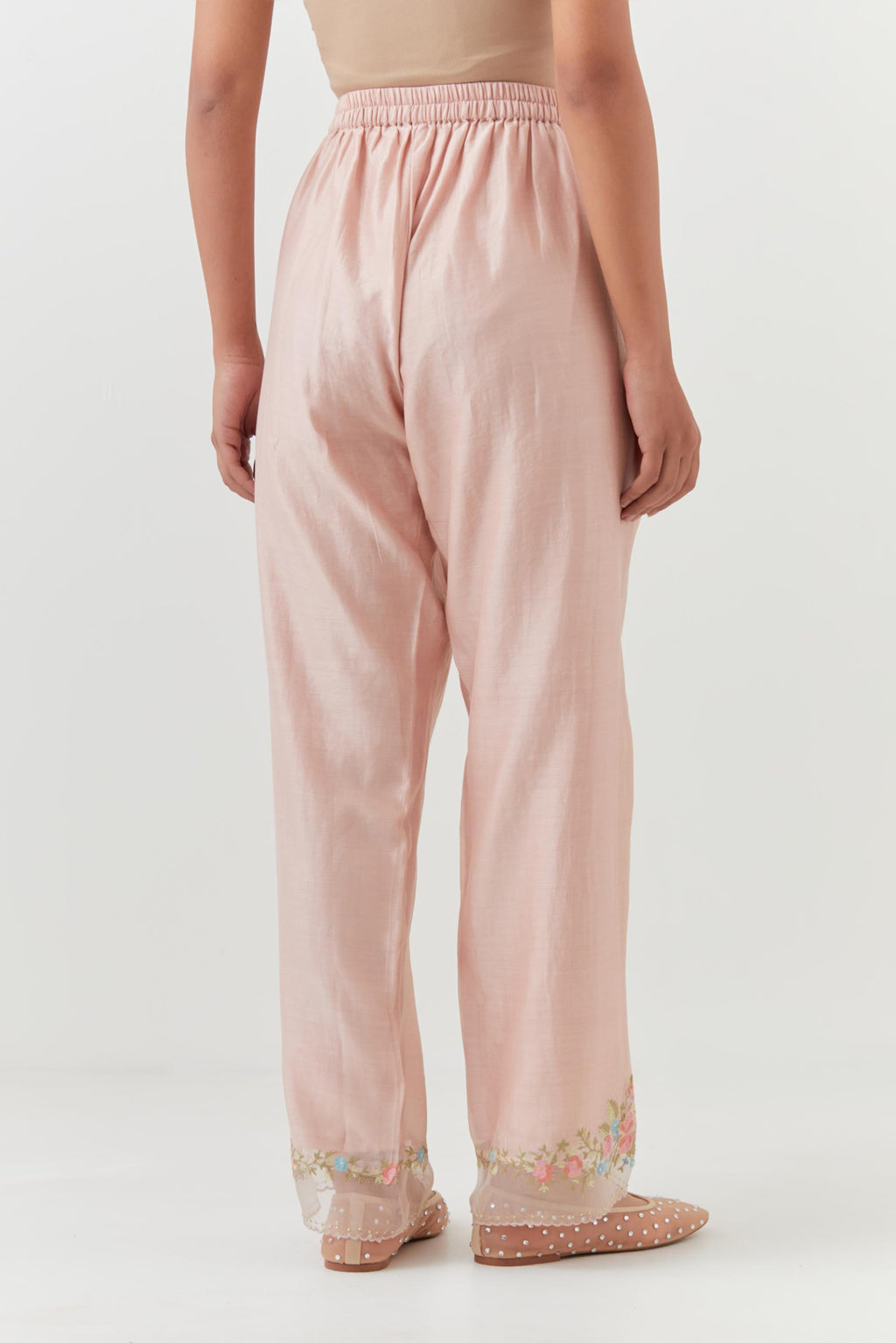 Pink silk chanderi straight pants with a broad organza scalloped hem, highlighted with embroidered rose flower bunches and beads.