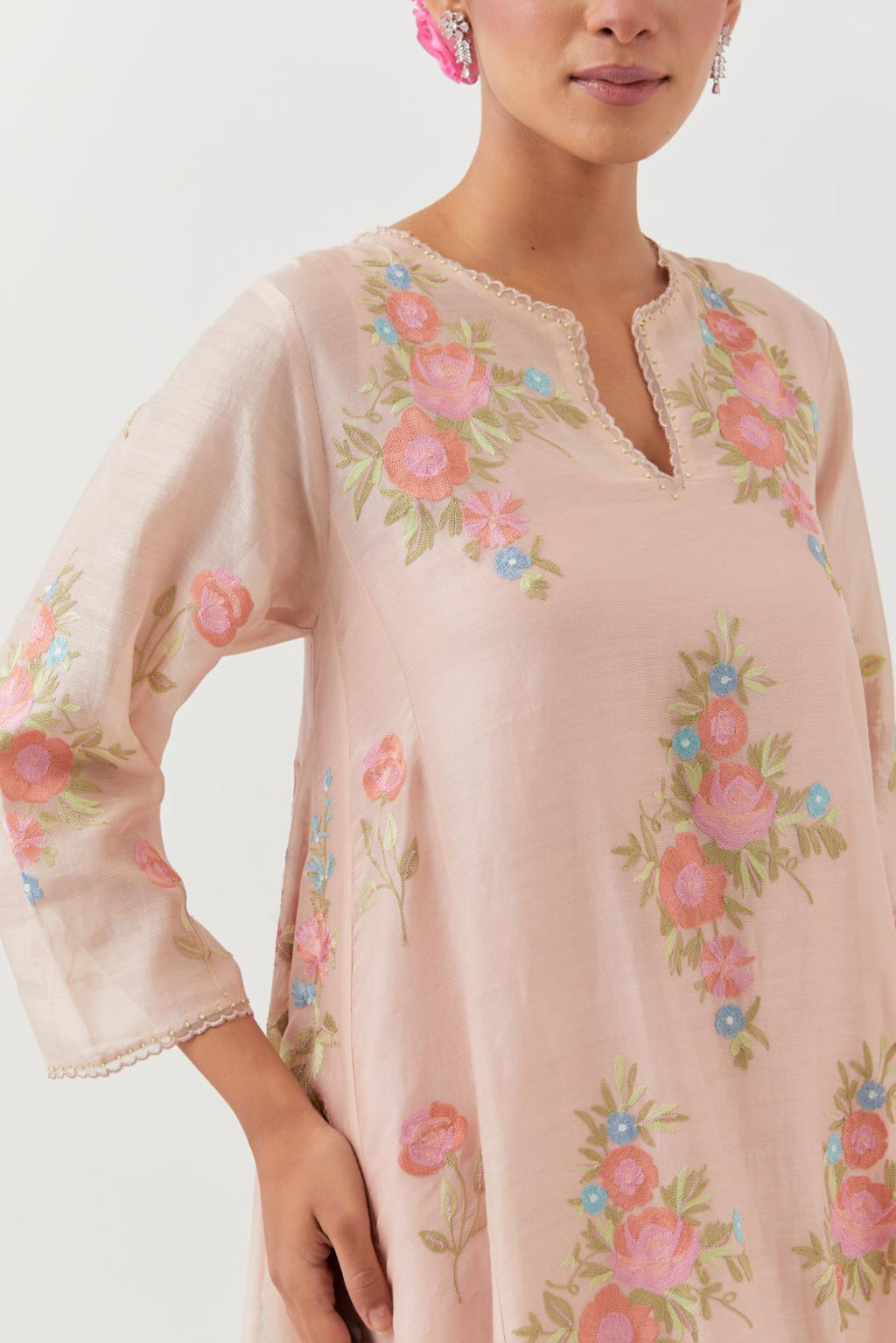 Pink silk chanderi easy fit, asymmetric hem, paneled kurta set with all-over thread embroidered roses, highlighted with scalloped organza at the edges with contrast beads.