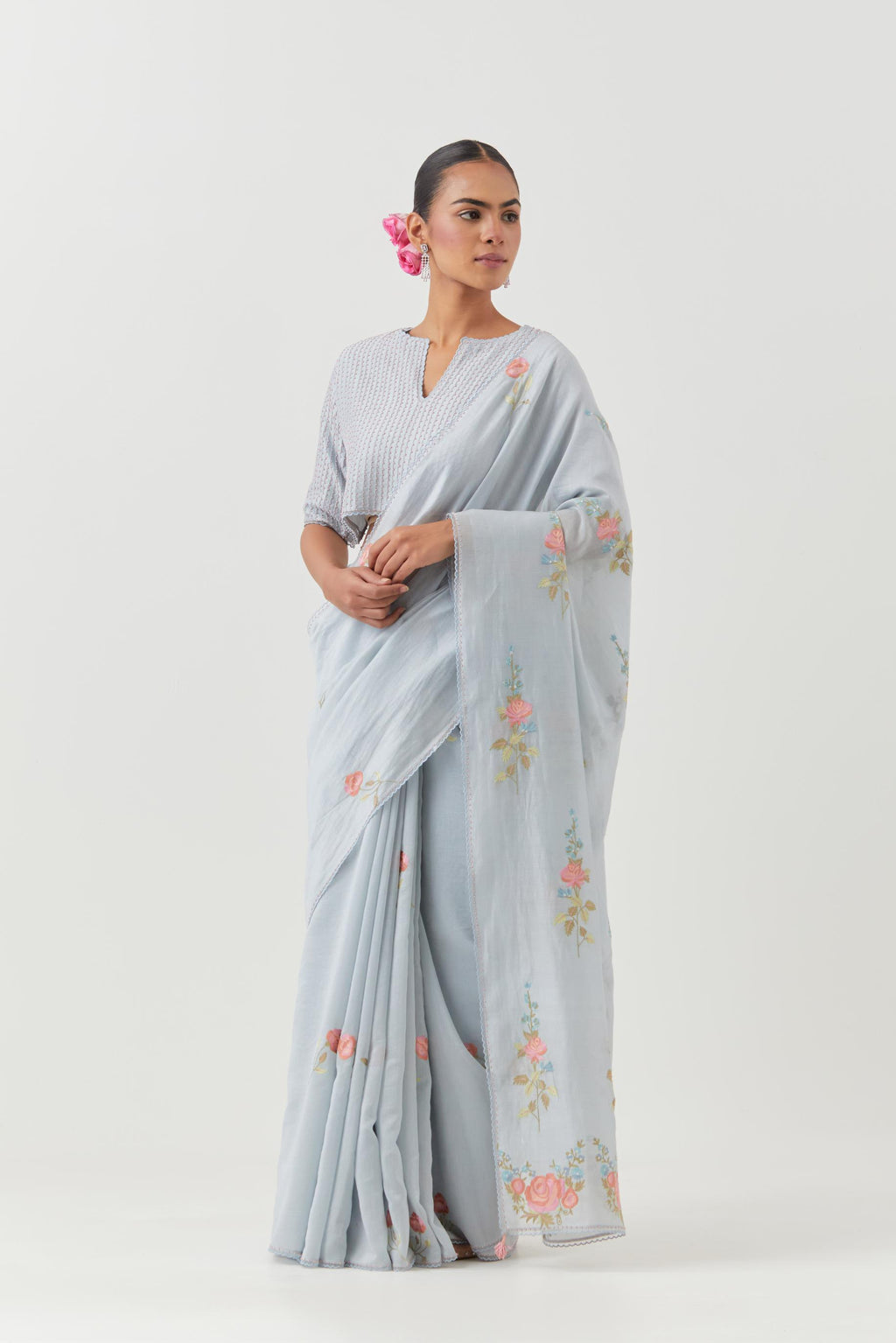 Blue silk chanderi saree with all-over thread embroidered roses and scalloped organza with delicate bead detail at the edges, paired with blue silk blouse with pin tucks, highlighted with bead work.