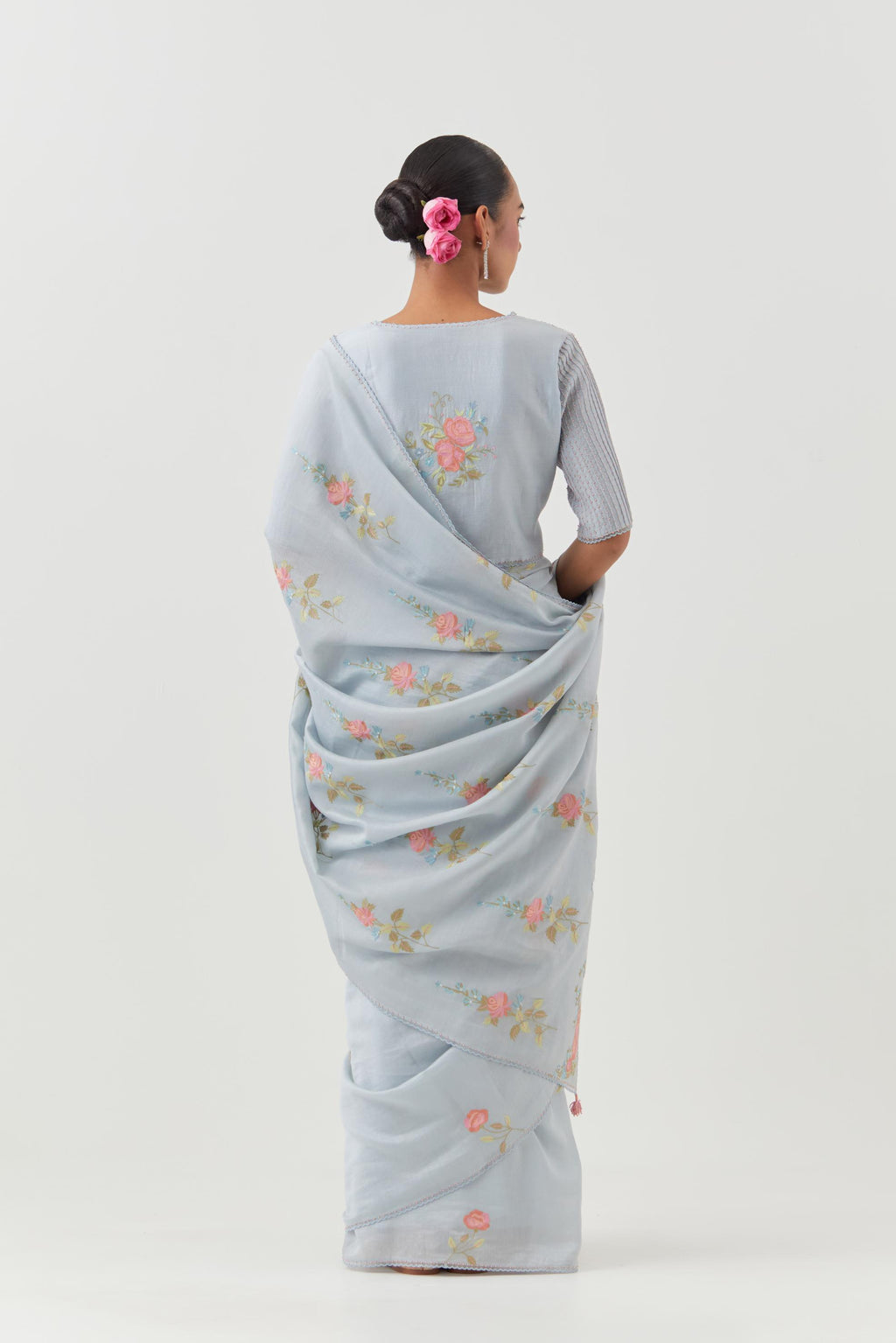 Blue silk chanderi saree with all-over thread embroidered roses and scalloped organza with delicate bead detail at the edges, paired with blue silk blouse with pin tucks, highlighted with bead work.