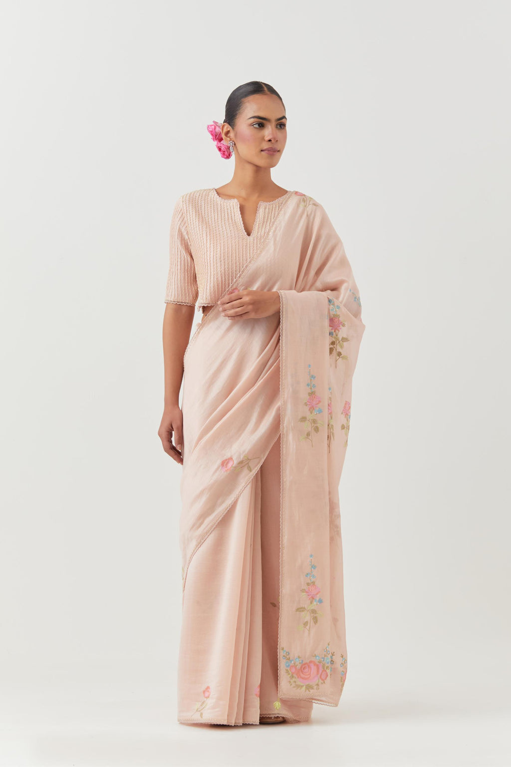 Pink silk chanderi saree with all-over thread embroidered roses and scalloped organza with delicate bead detail at the edges, paired with pink silk blouse with pin tucks, highlighted with bead work.