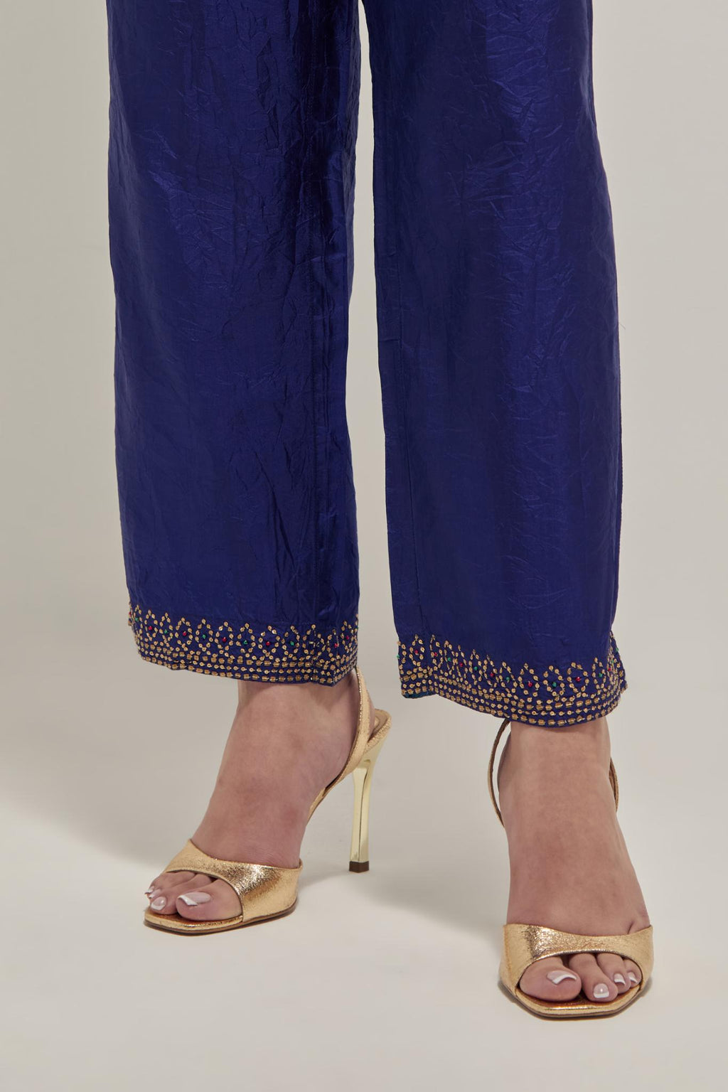 Blue silk pants with a narrow bandhani-inspired border at the hem, detailed with delicate bead and sequin work.