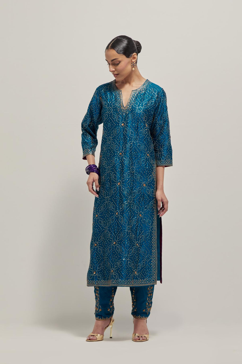 Teal silk straight kurta set with hand embroidered sequins on bandhani inspired jaal all-over the kurta, highlighted with contrast-colored beads.