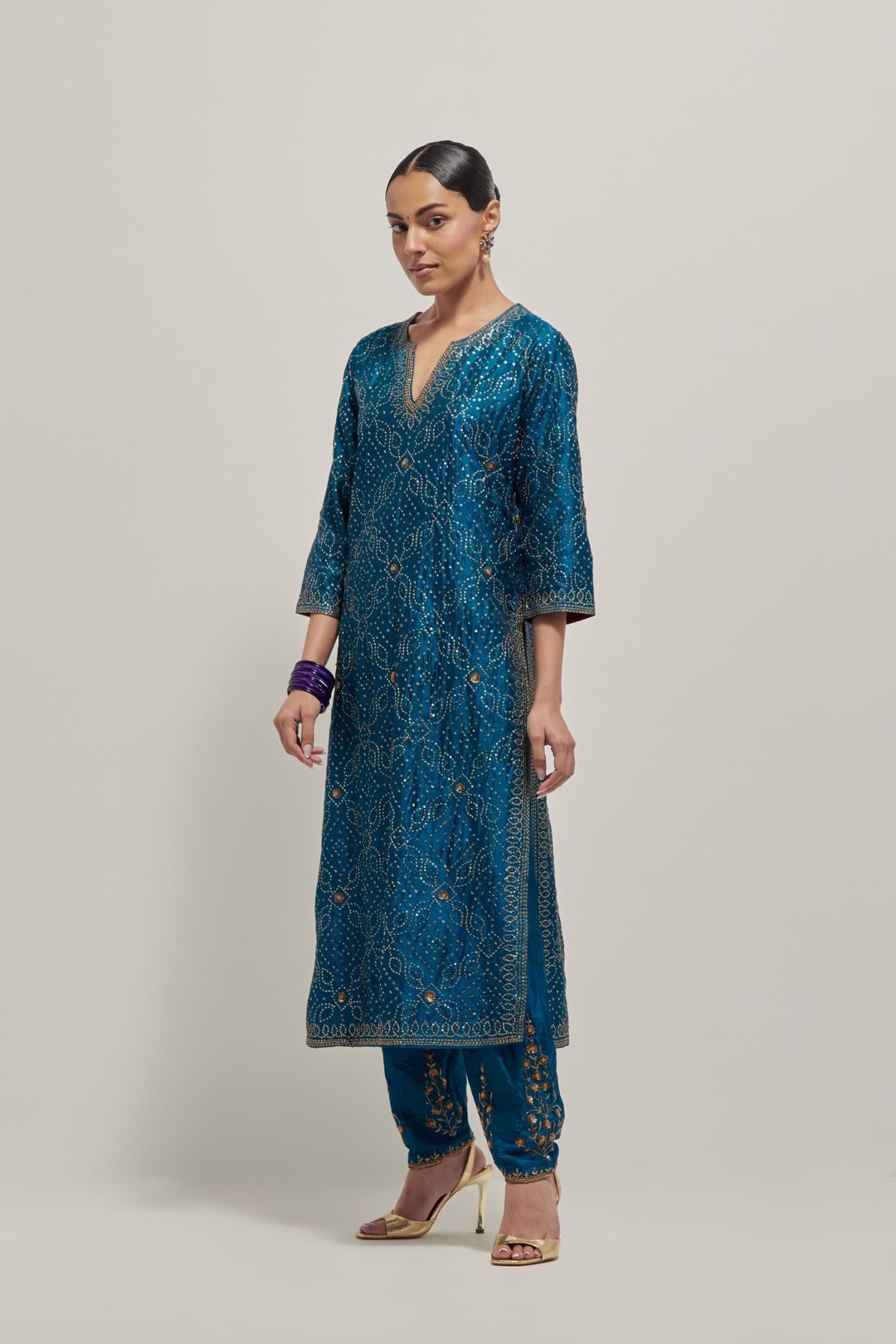 Teal silk straight kurta set with hand embroidered sequins on bandhani inspired jaal all-over the kurta, highlighted with contrast-colored beads.