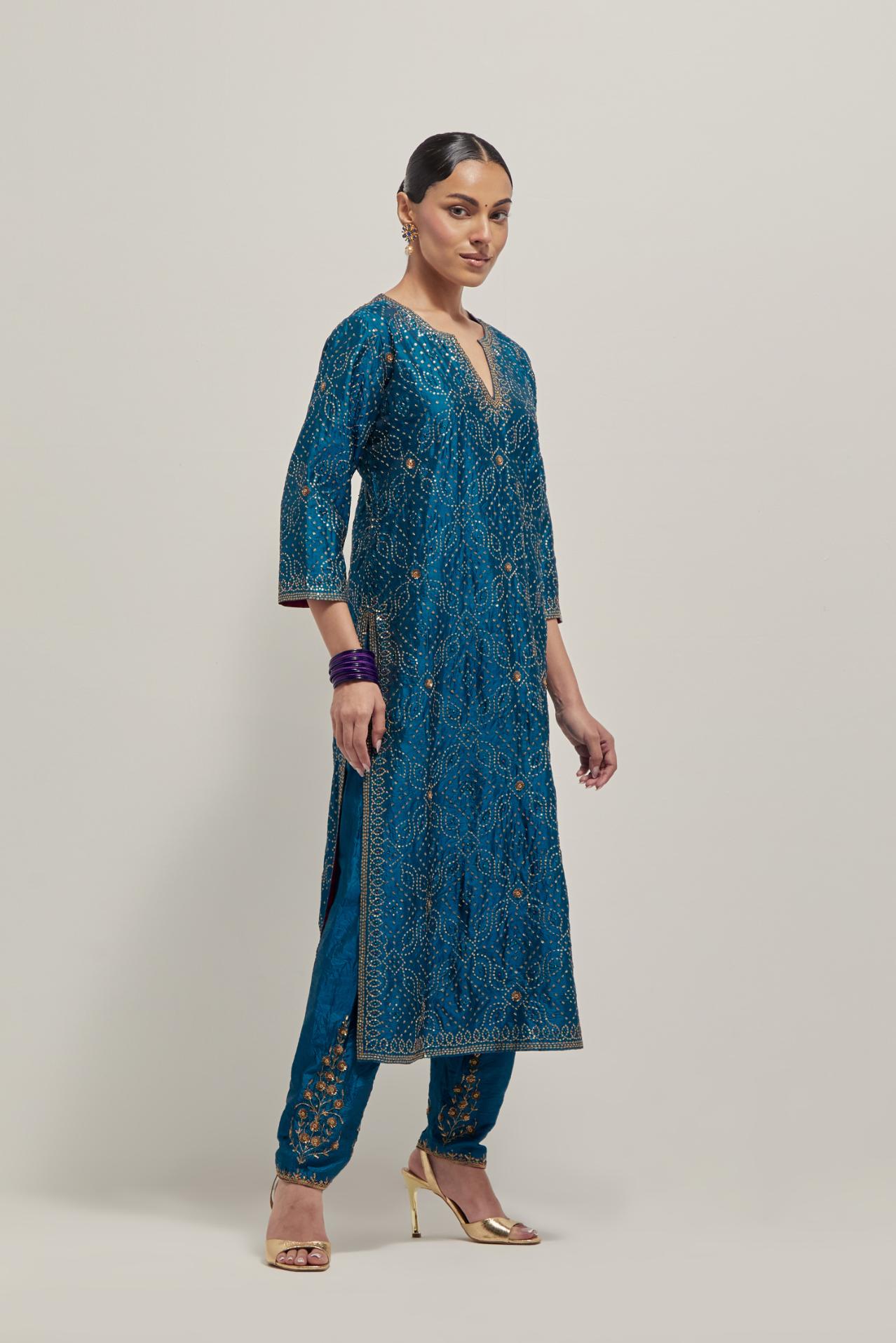 Teal silk straight kurta set with hand embroidered sequins on bandhani inspired jaal all-over the kurta, highlighted with contrast-colored beads.