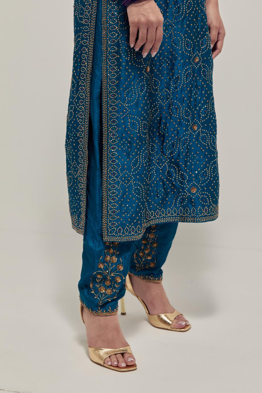 Teal silk straight kurta set with hand embroidered sequins on bandhani inspired jaal all-over the kurta, highlighted with contrast-colored beads.