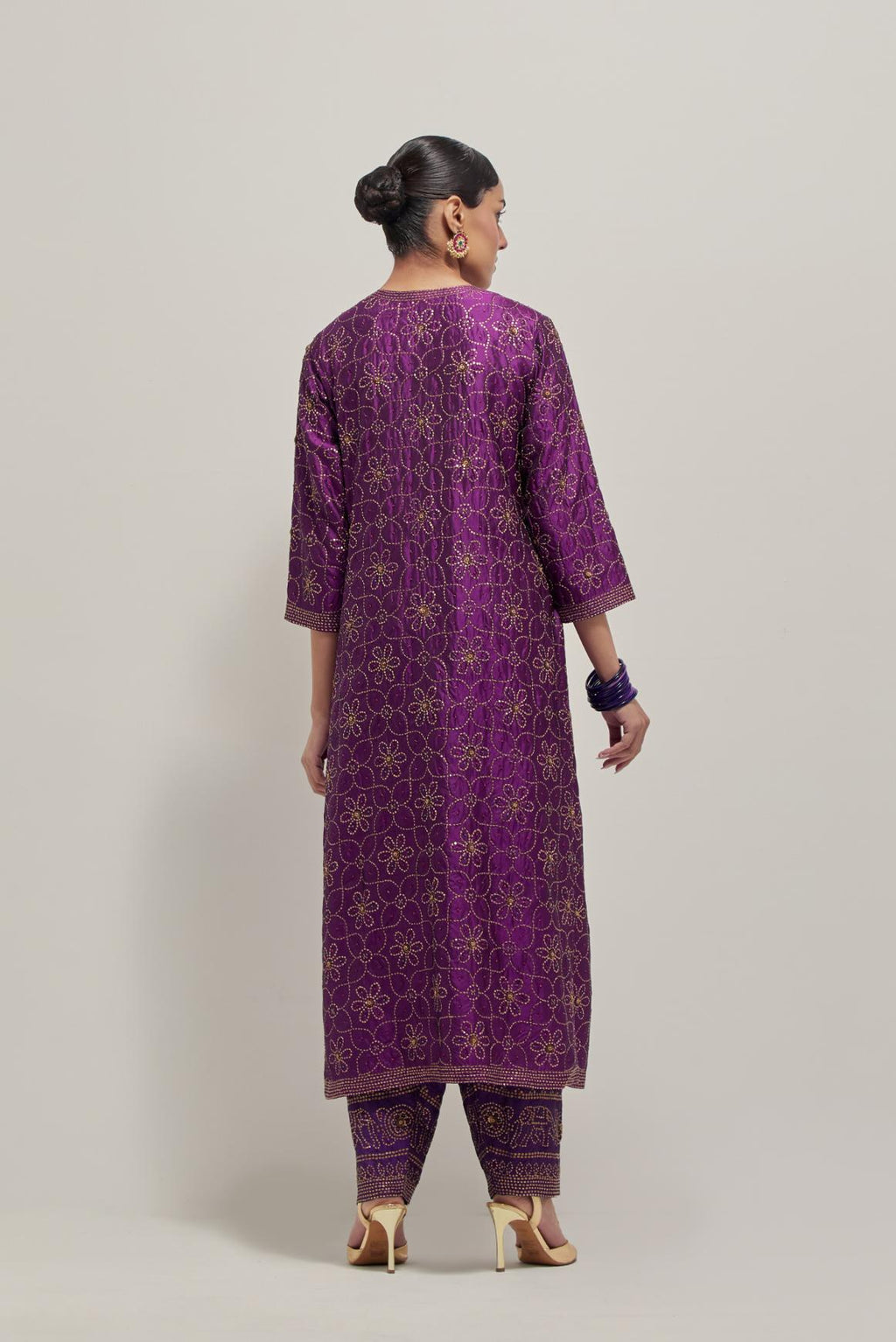 Purple silk straight kurta set with hand embroidered sequins on bandhani inspired floral jaal all-over the kurta, highlighted with contrast-colored beads.