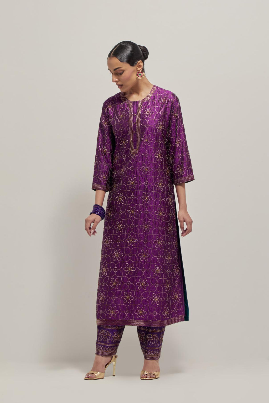 Purple silk straight kurta set with hand embroidered sequins on bandhani inspired floral jaal all-over the kurta, highlighted with contrast-colored beads.