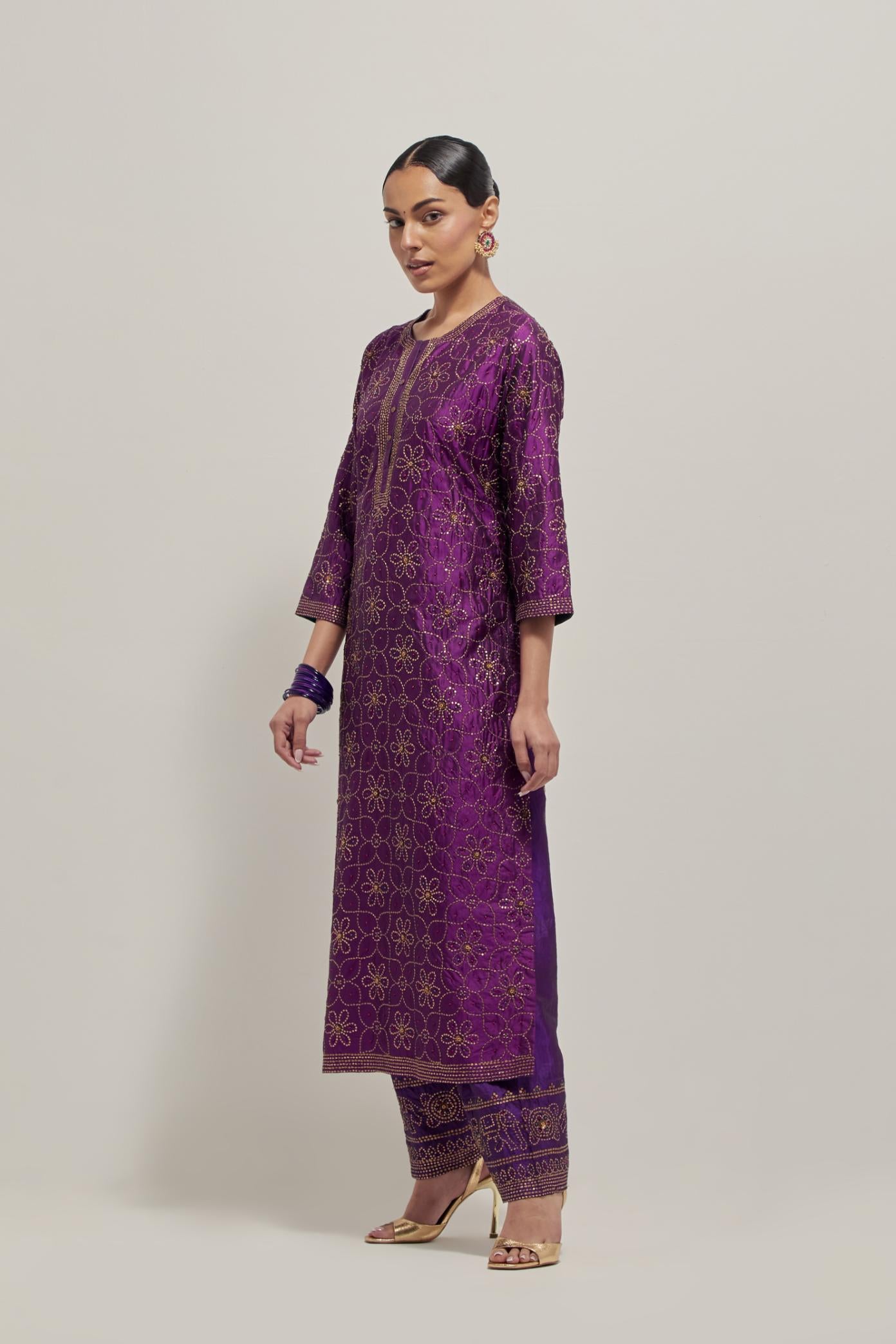 Purple silk straight kurta set with hand embroidered sequins on bandhani inspired floral jaal all-over the kurta, highlighted with contrast-colored beads.
