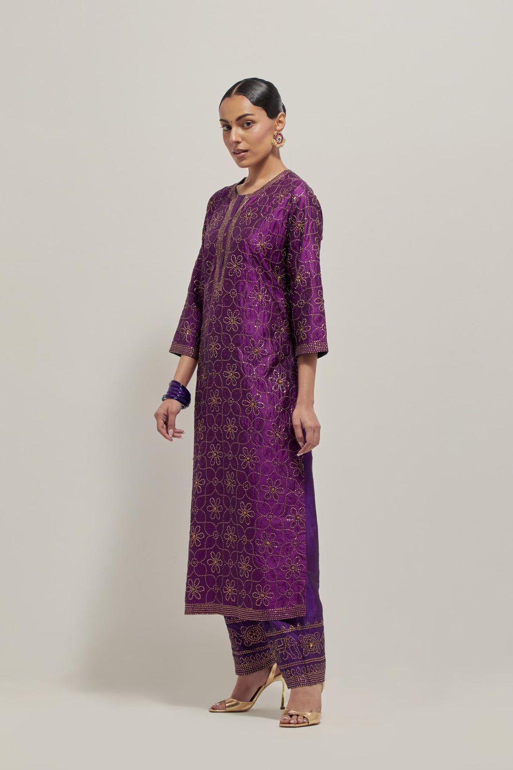 Purple silk straight kurta set with hand embroidered sequins on bandhani inspired floral jaal all-over the kurta, highlighted with contrast-colored beads.