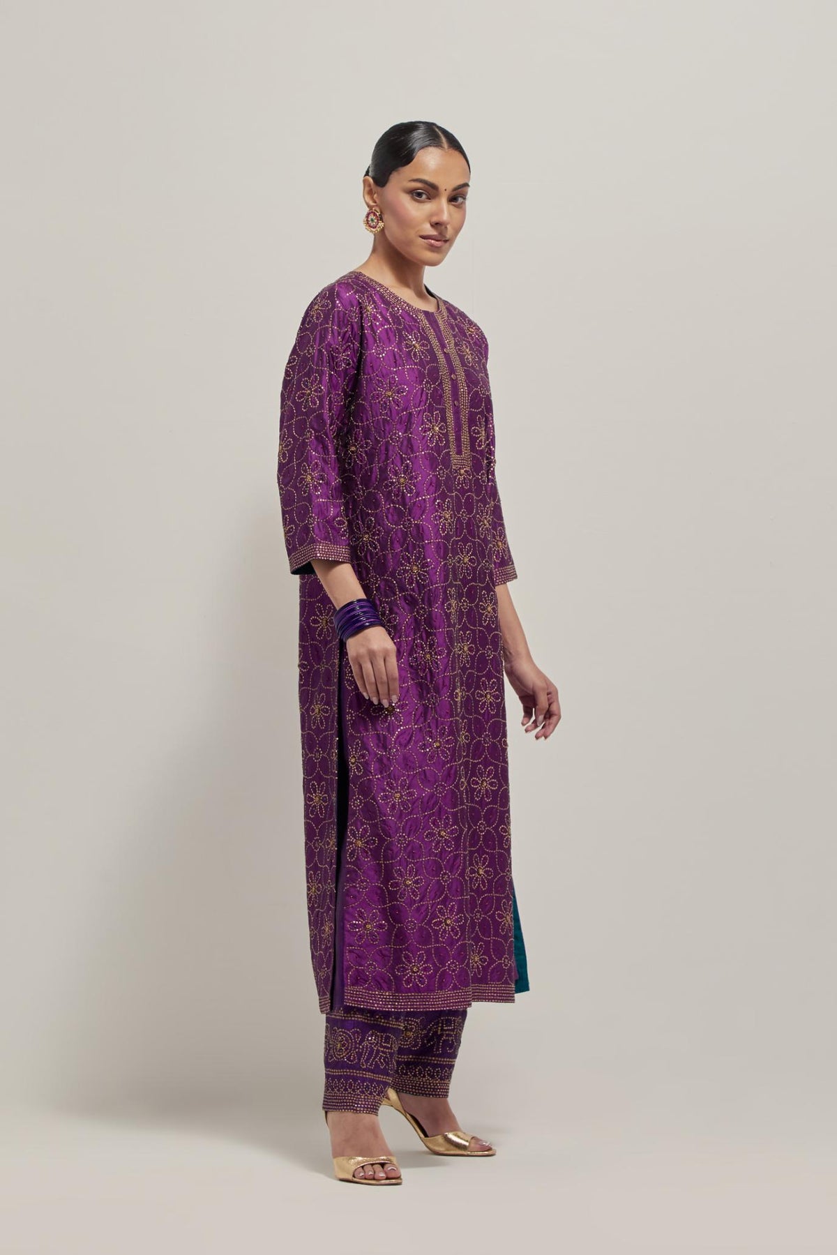 Purple silk straight kurta set with hand embroidered sequins on bandhani inspired floral jaal all-over the kurta, highlighted with contrast-colored beads.