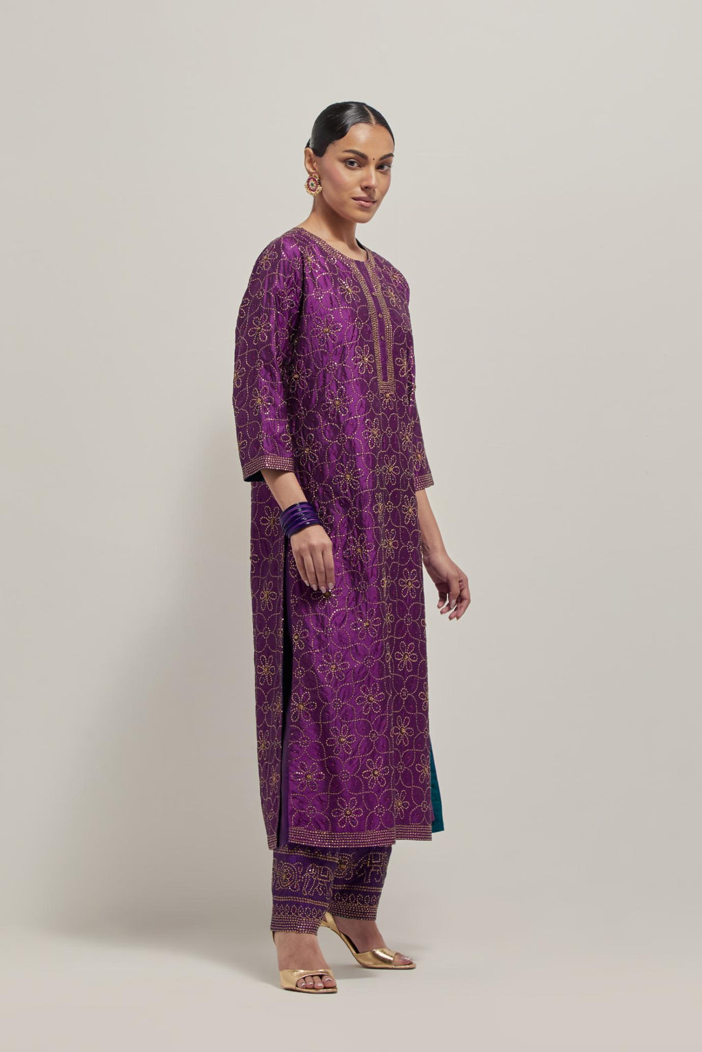 Purple silk straight kurta set with hand embroidered sequins on bandhani inspired floral jaal all-over the kurta, highlighted with contrast-colored beads.