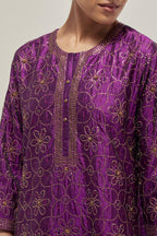 Purple silk straight kurta set with hand embroidered sequins on bandhani inspired floral jaal all-over the kurta, highlighted with contrast-colored beads.