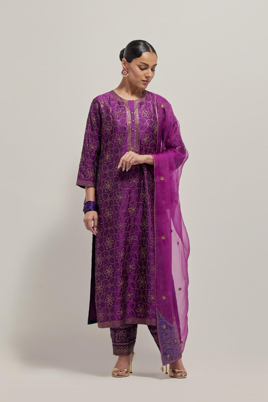 Purple silk straight kurta set with hand embroidered sequins on bandhani inspired floral jaal all-over the kurta, highlighted with contrast-colored beads.