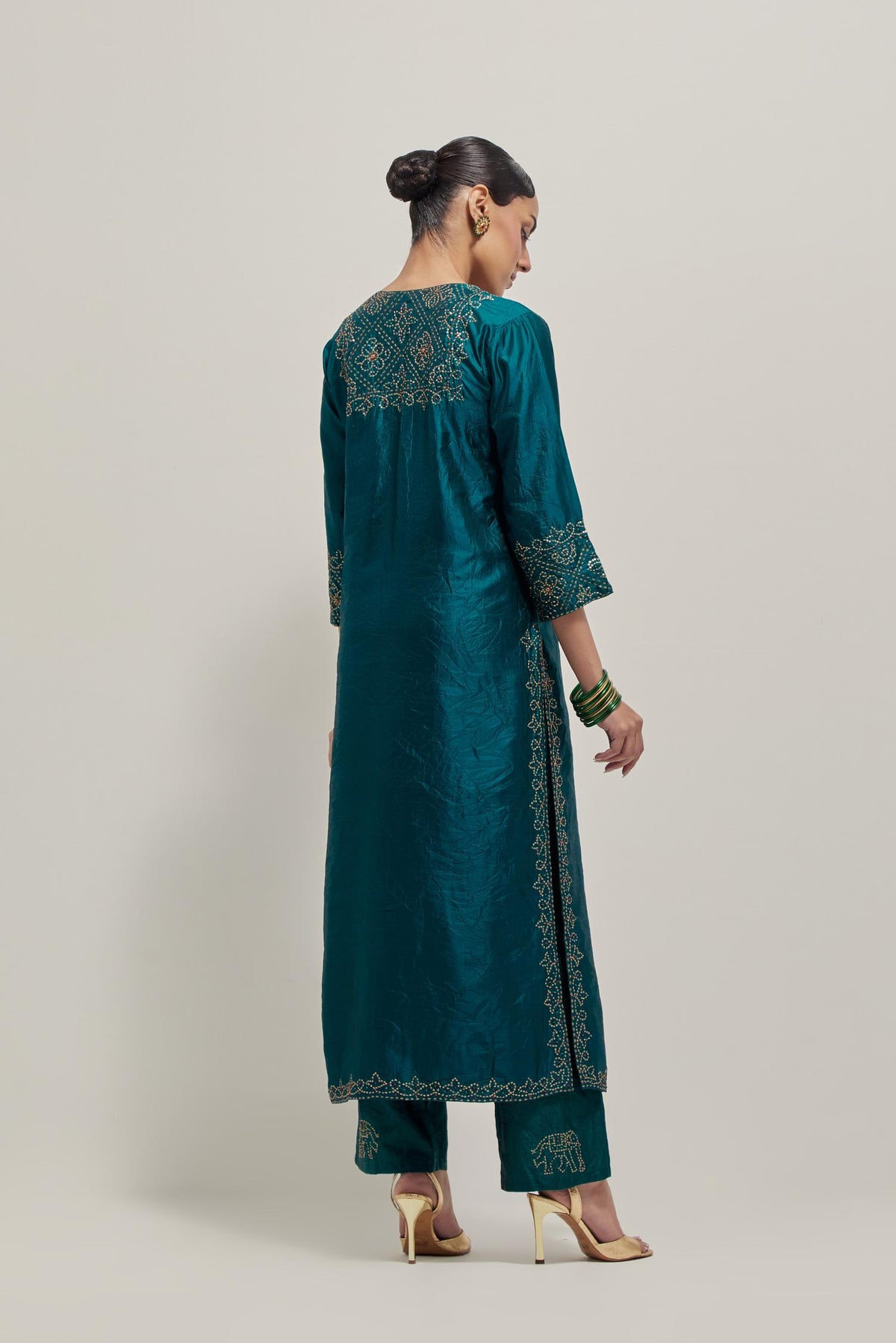 Teal Silk kurta set with hand embroidered sequins on bandhani inspired jaal work at neck, hem and sleeves cuff, highlighted with contrast-colored beads.