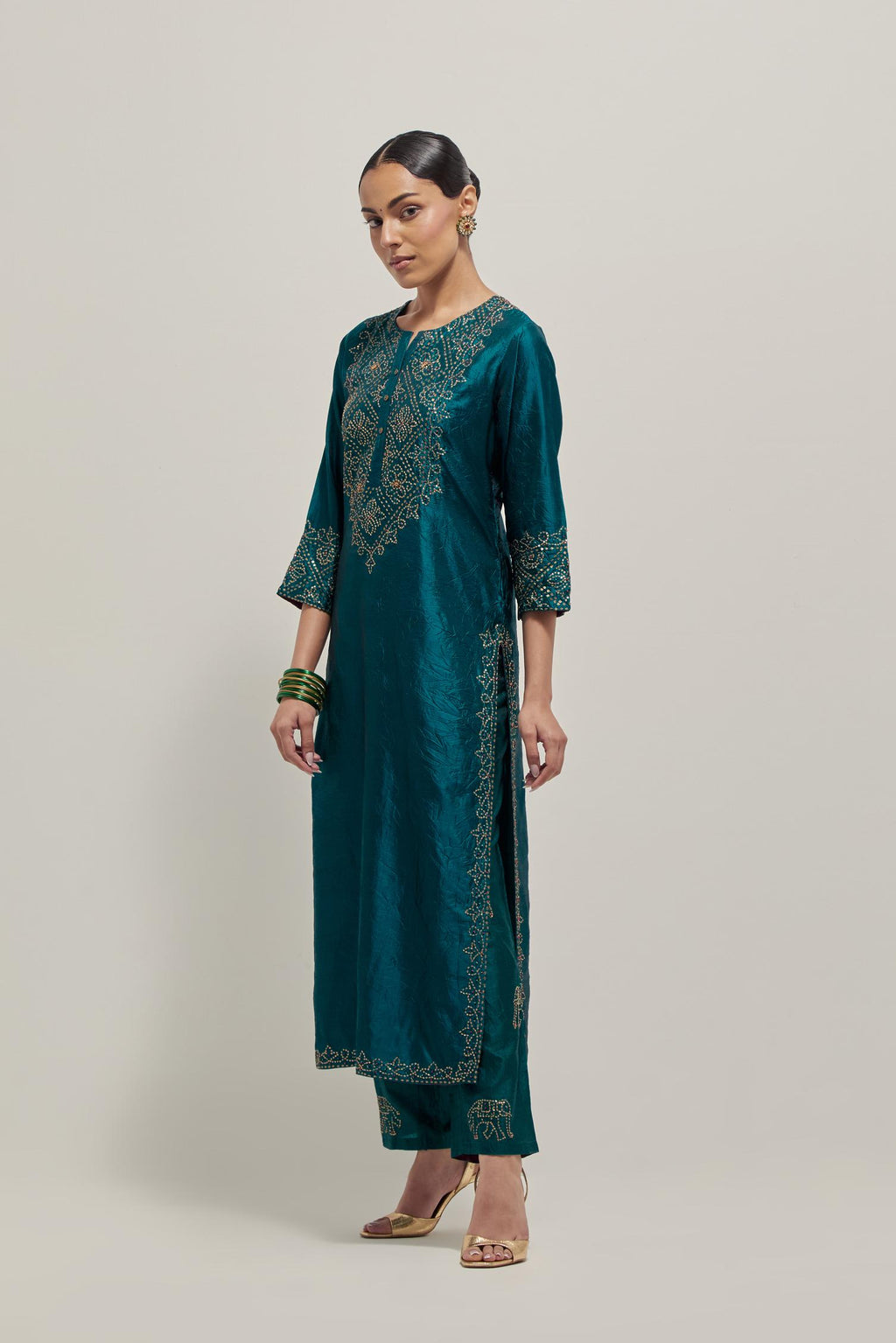 Teal Silk kurta set with hand embroidered sequins on bandhani inspired jaal work at neck, hem and sleeves cuff, highlighted with contrast-colored beads.