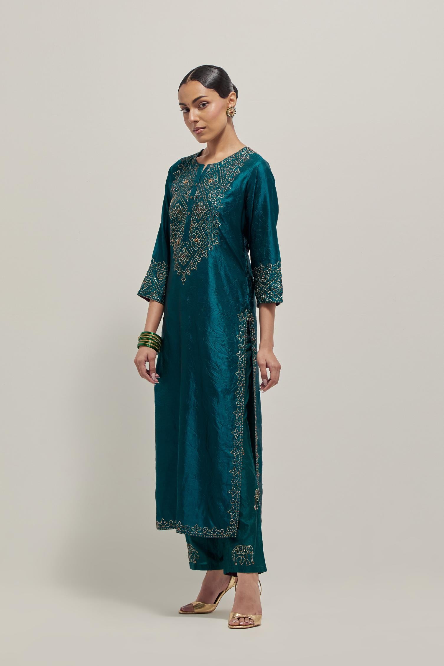 Teal Silk kurta set with hand embroidered sequins on bandhani inspired jaal work at neck, hem and sleeves cuff, highlighted with contrast-colored beads.
