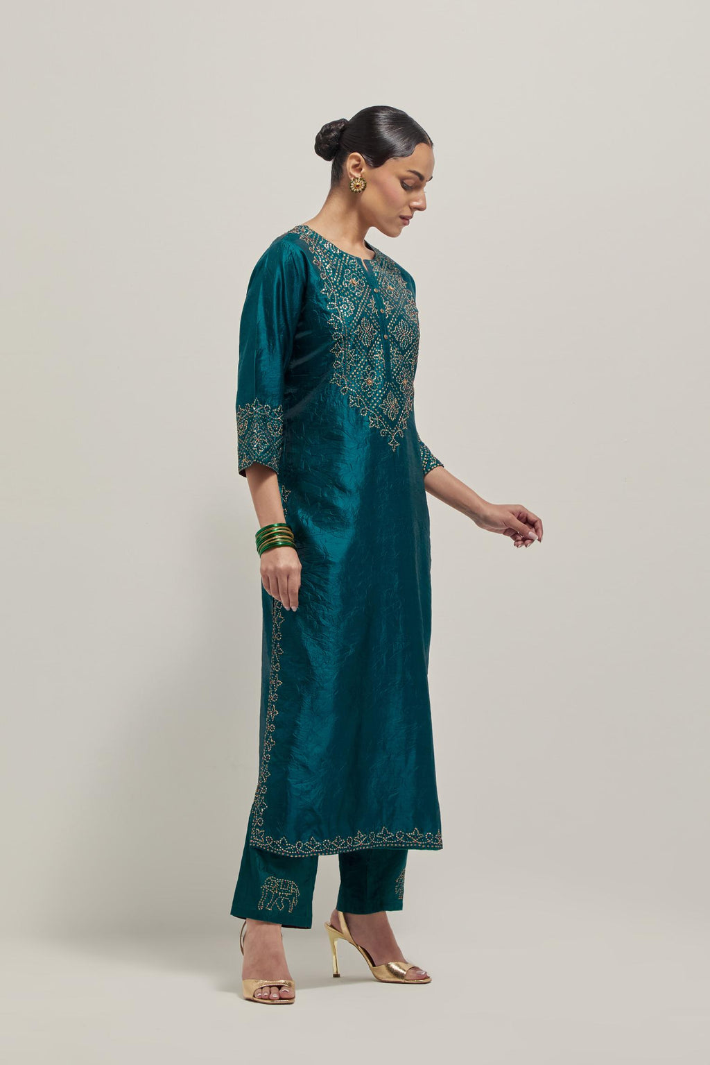 Teal Silk kurta set with hand embroidered sequins on bandhani inspired jaal work at neck, hem and sleeves cuff, highlighted with contrast-colored beads.