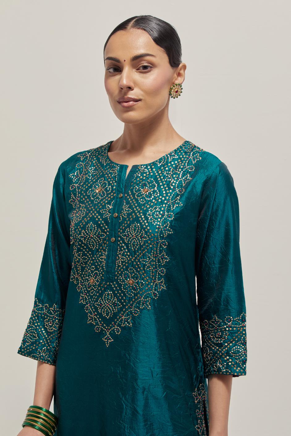 Teal Silk kurta set with hand embroidered sequins on bandhani inspired jaal work at neck, hem and sleeves cuff, highlighted with contrast-colored beads.