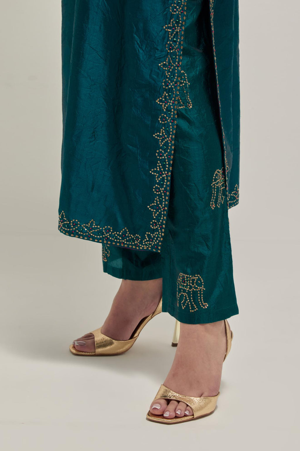 Teal Silk kurta set with hand embroidered sequins on bandhani inspired jaal work at neck, hem and sleeves cuff, highlighted with contrast-colored beads.
