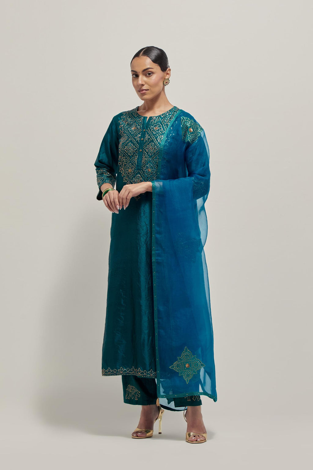 Teal Silk kurta set with hand embroidered sequins on bandhani inspired jaal work at neck, hem and sleeves cuff, highlighted with contrast-colored beads.