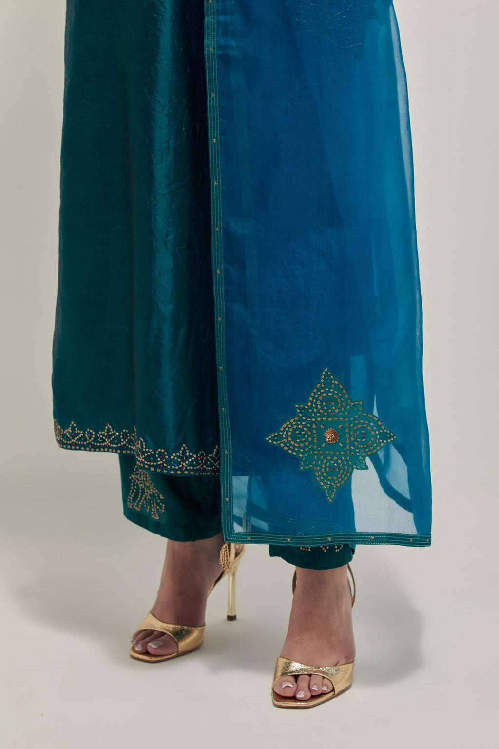 Teal Silk kurta set with hand embroidered sequins on bandhani inspired jaal work at neck, hem and sleeves cuff, highlighted with contrast-colored beads.