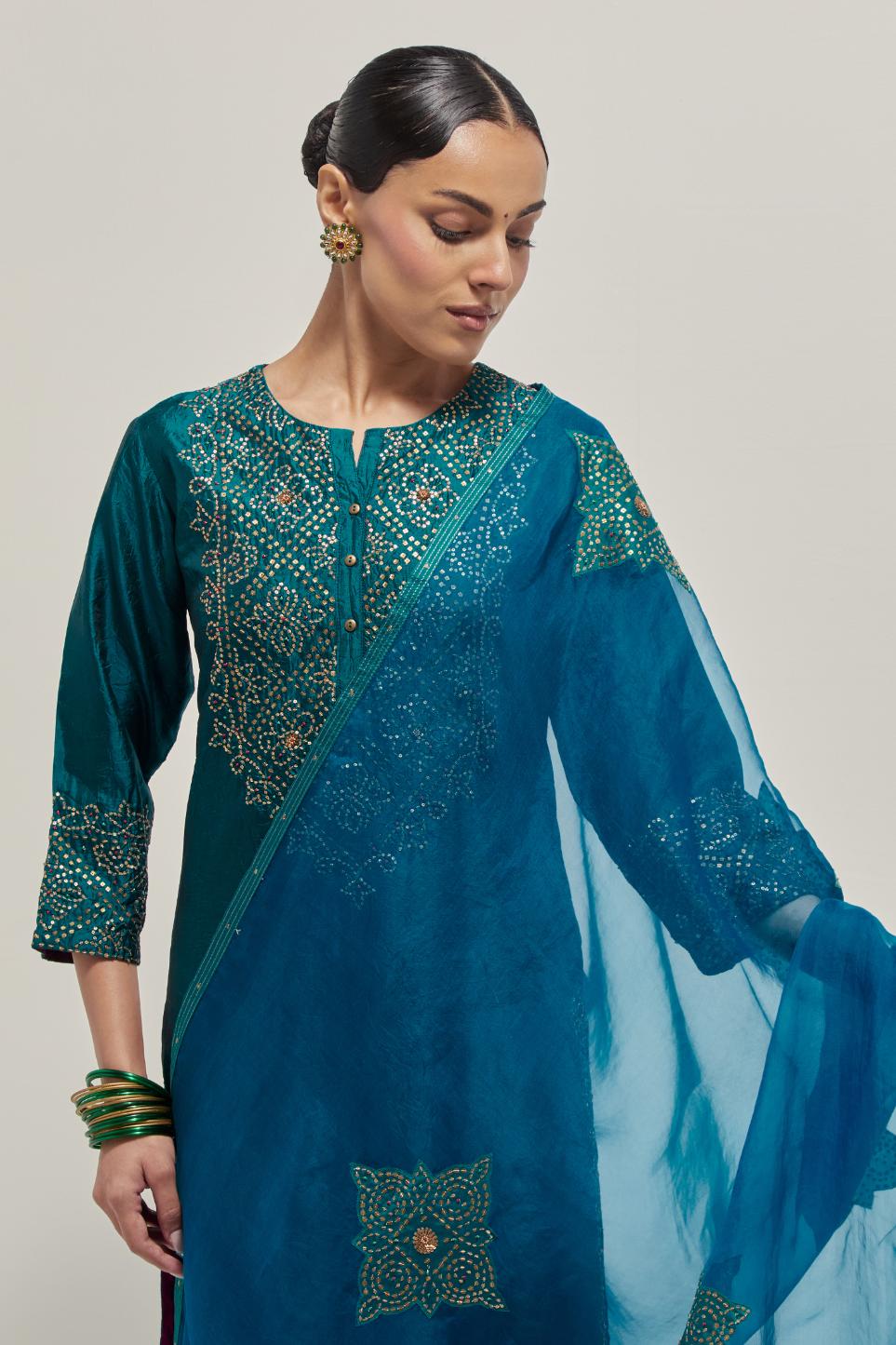 Teal Silk kurta set with hand embroidered sequins on bandhani inspired jaal work at neck, hem and sleeves cuff, highlighted with contrast-colored beads.