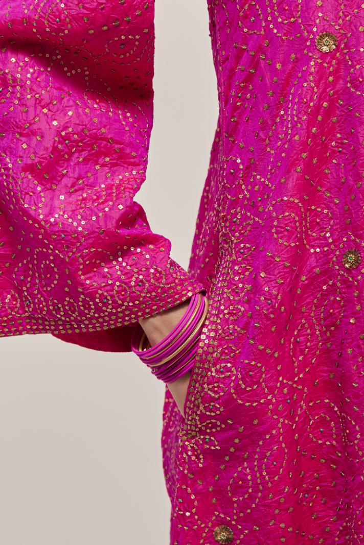 Fuchsia silk A-line kurta set with hand embroidered sequins on bandhani inspired jaal all-over the kurta, highlighted with contrast-colored beads.