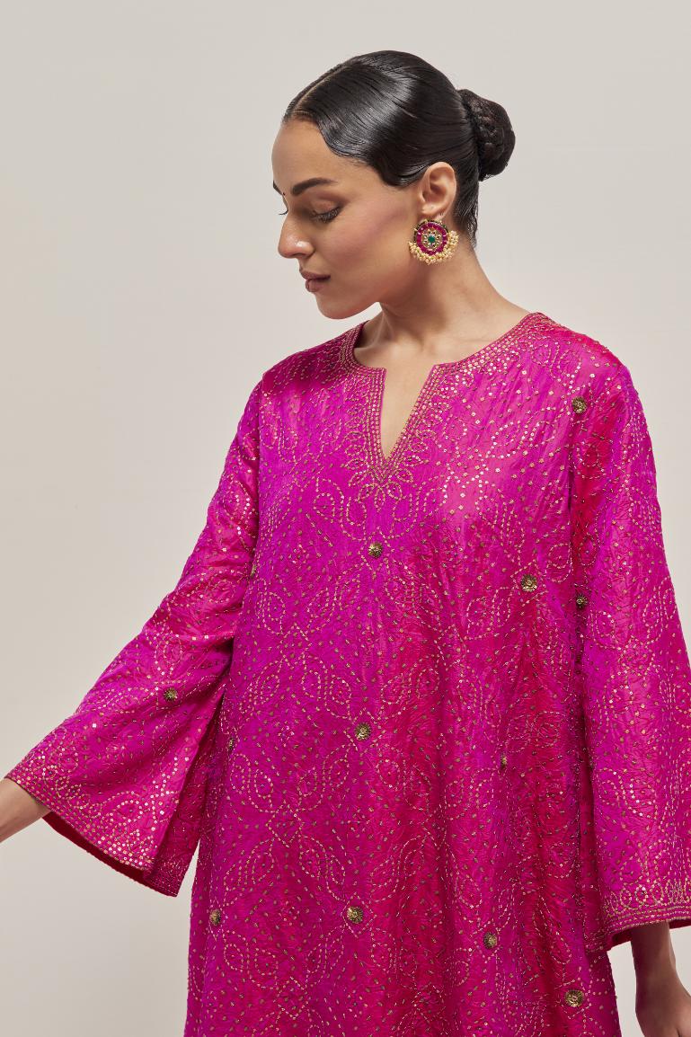 Fuchsia silk A-line kurta set with hand embroidered sequins on bandhani inspired jaal all-over the kurta, highlighted with contrast-colored beads.
