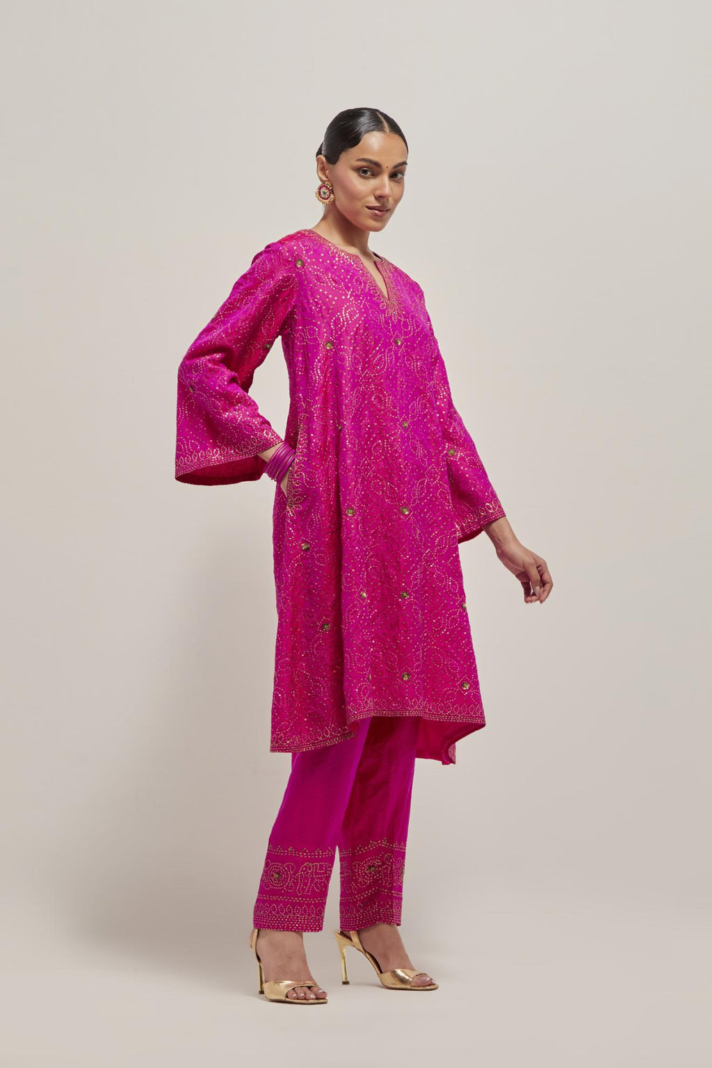 Fuchsia silk A-line kurta set with hand embroidered sequins on bandhani inspired jaal all-over the kurta, highlighted with contrast-colored beads.
