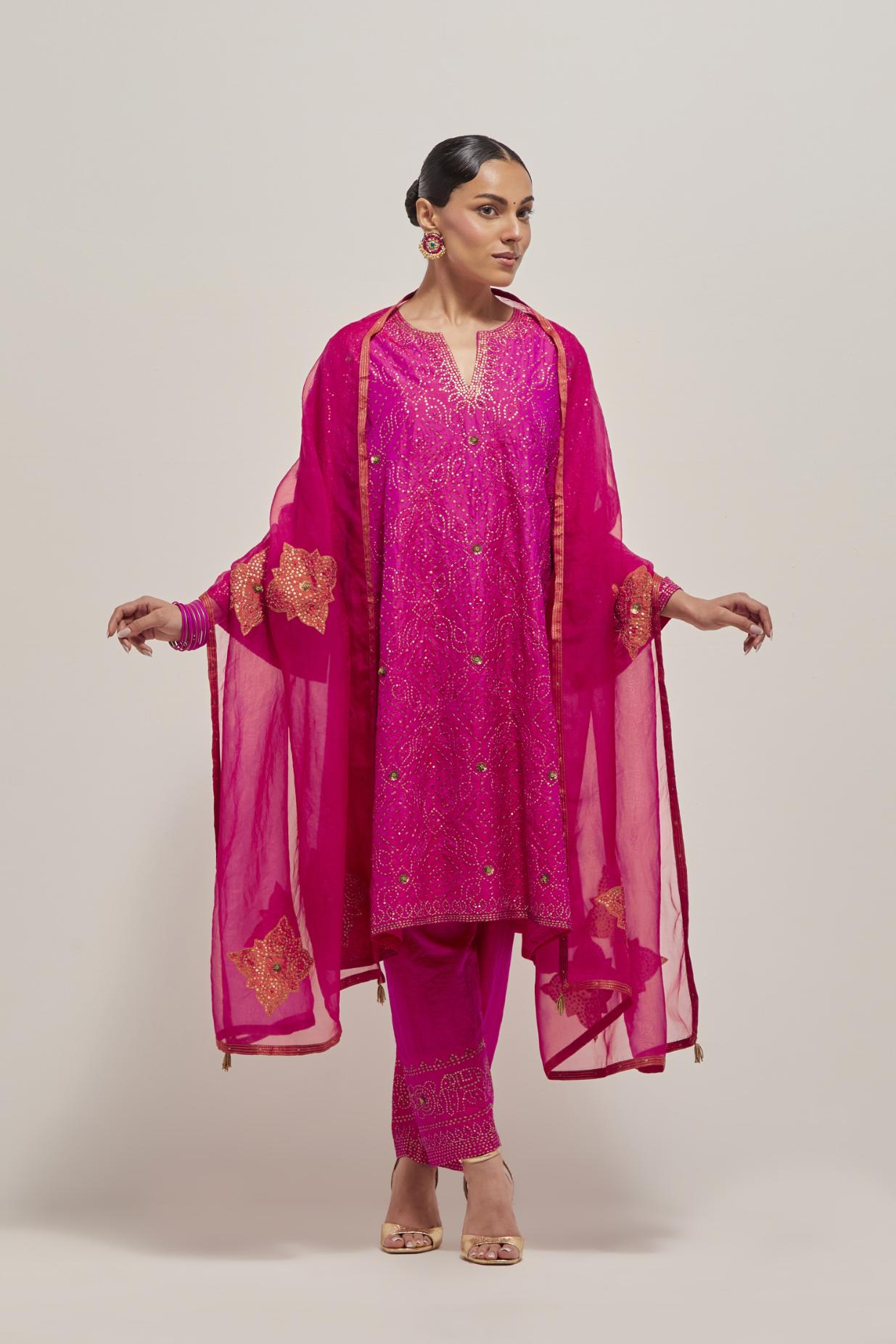 Fuchsia silk A-line kurta set with hand embroidered sequins on bandhani inspired jaal all-over the kurta, highlighted with contrast-colored beads.