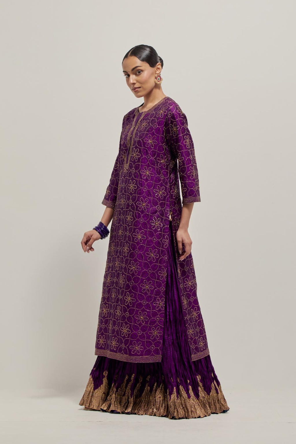 Purple silk straight kurta set with hand embroidered sequins on bandhani inspired floral jaal all-over the kurta, highlighted with contrast-colored beads.
