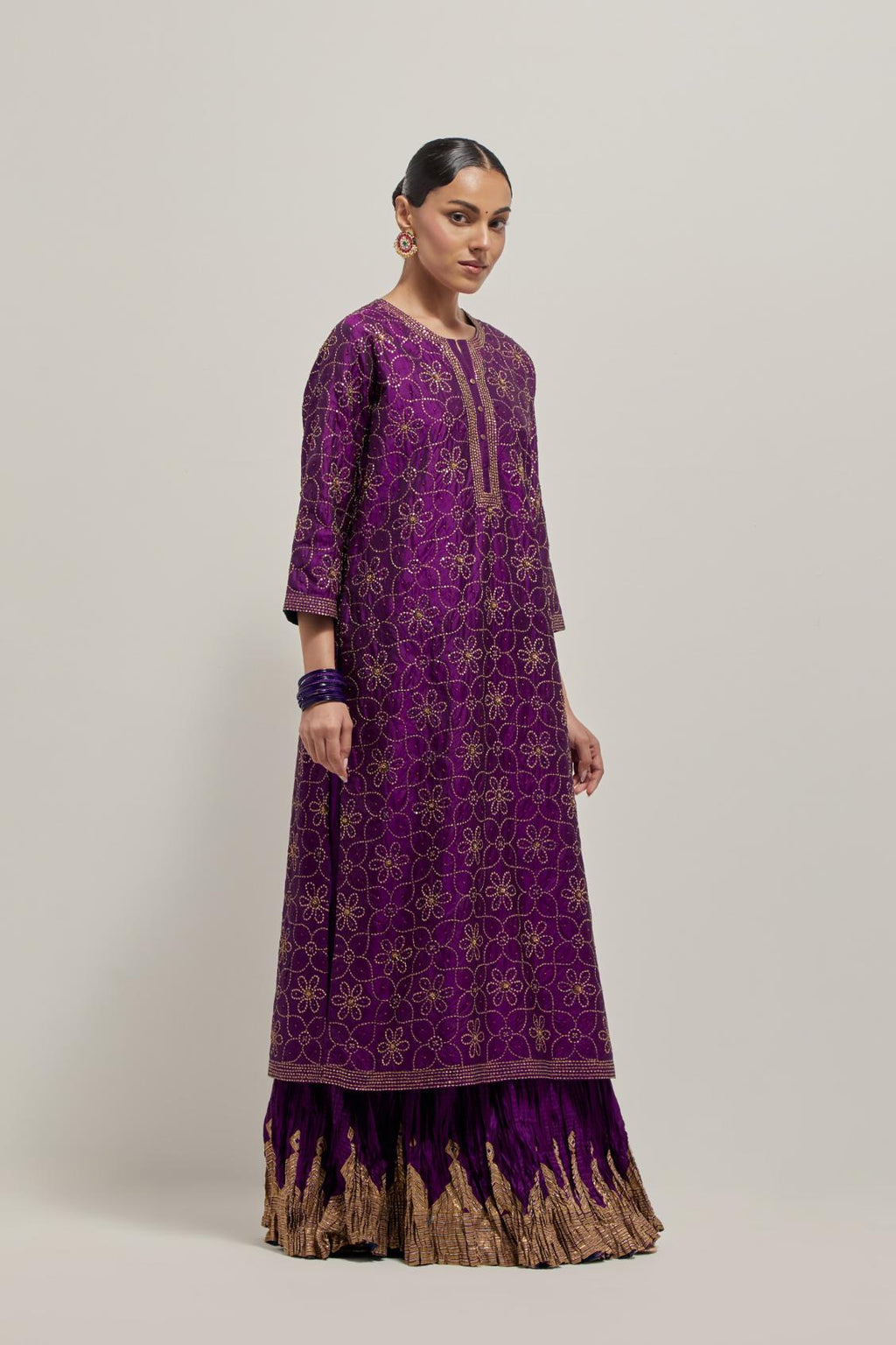 Purple silk straight kurta set with hand embroidered sequins on bandhani inspired floral jaal all-over the kurta, highlighted with contrast-colored beads.