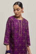 Purple silk straight kurta set with hand embroidered sequins on bandhani inspired floral jaal all-over the kurta, highlighted with contrast-colored beads.