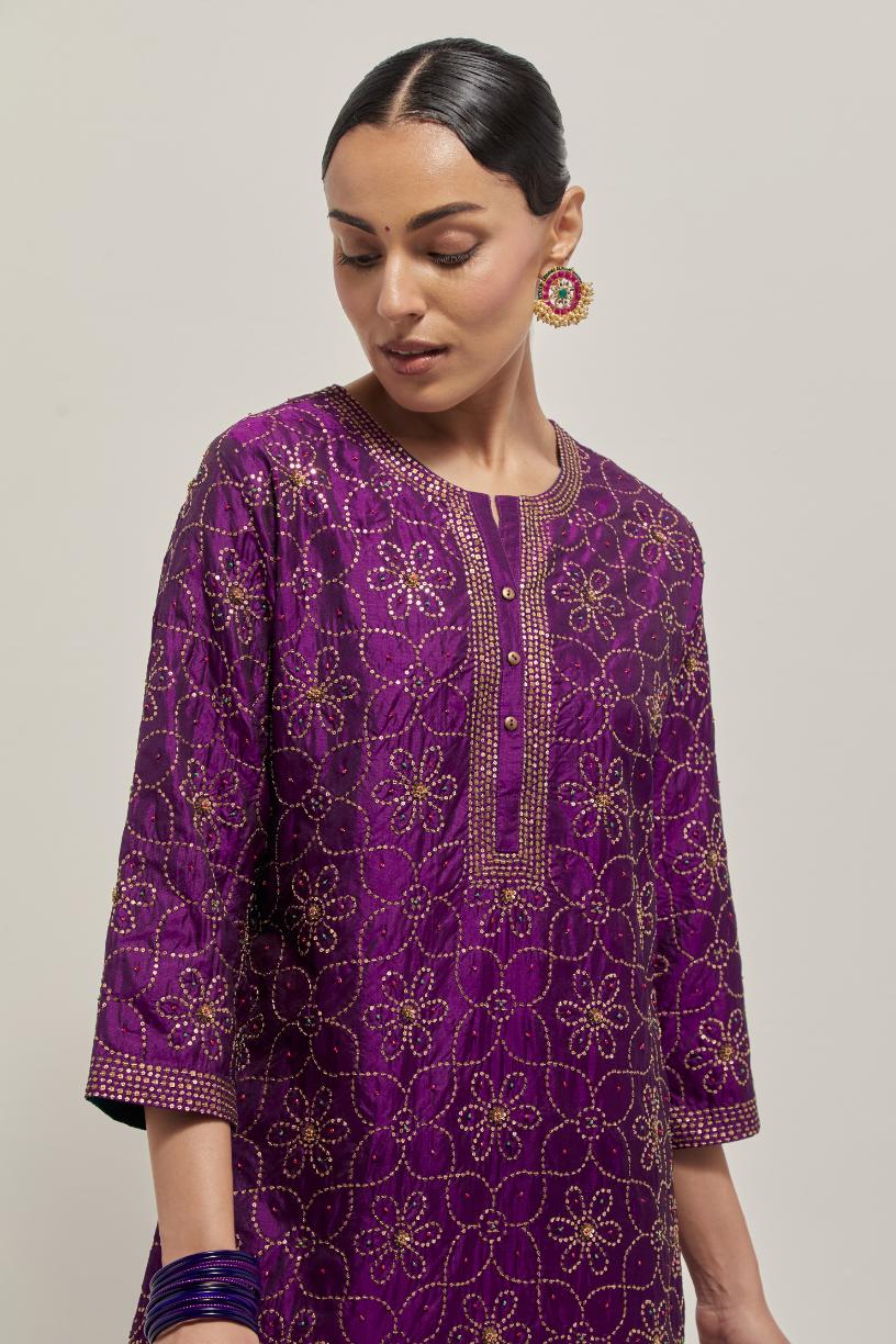 Purple silk straight kurta set with hand embroidered sequins on bandhani inspired floral jaal all-over the kurta, highlighted with contrast-colored beads.