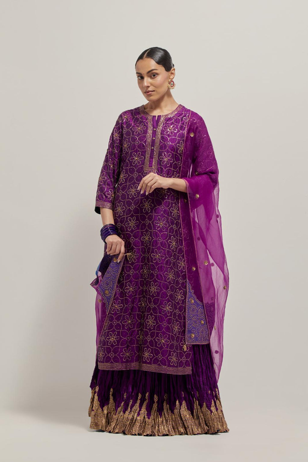 Purple silk straight kurta set with hand embroidered sequins on bandhani inspired floral jaal all-over the kurta, highlighted with contrast-colored beads.