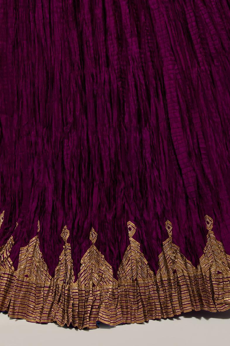 Wine Silk 40 kali lehenga edged with dull gold gota embroidery and contrast silk facings.