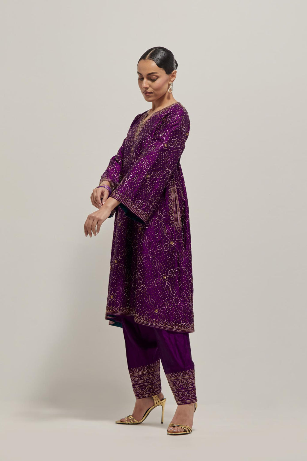 Purple silk A-line kurta set with hand embroidered sequins on bandhani inspired jaal all-over the kurta, highlighted with contrast-colored beads.