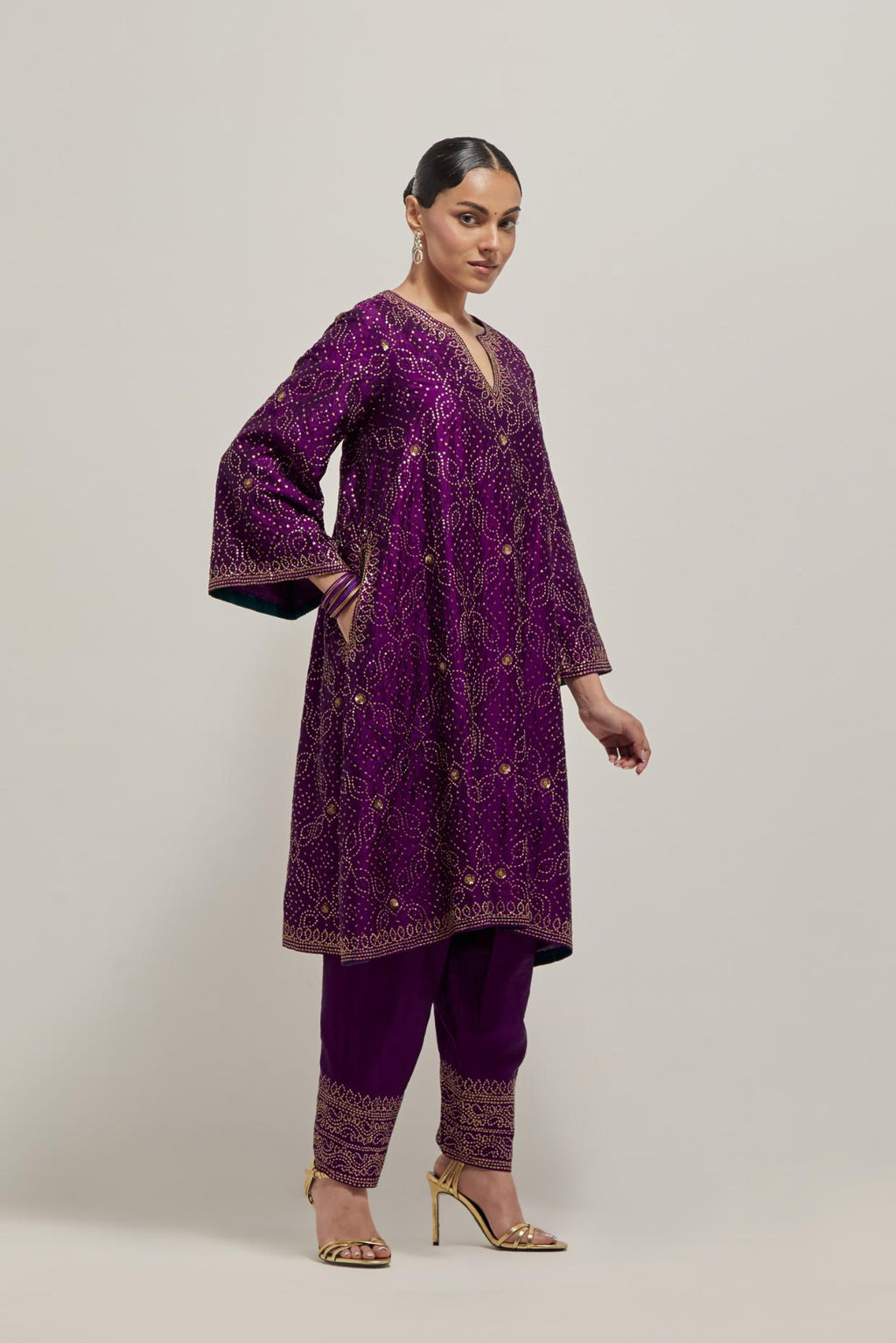 Purple silk A-line kurta set with hand embroidered sequins on bandhani inspired jaal all-over the kurta, highlighted with contrast-colored beads.
