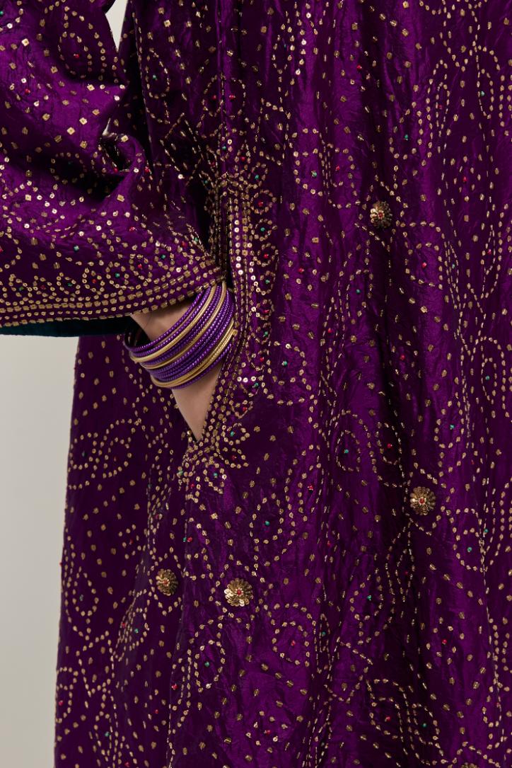 Purple silk A-line kurta set with hand embroidered sequins on bandhani inspired jaal all-over the kurta, highlighted with contrast-colored beads.