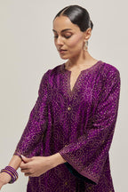 Purple silk A-line kurta set with hand embroidered sequins on bandhani inspired jaal all-over the kurta, highlighted with contrast-colored beads.