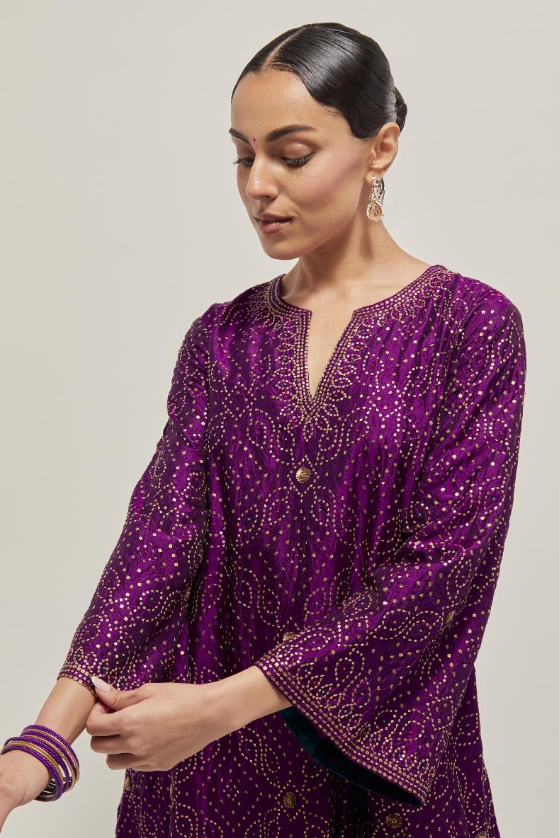 Purple silk A-line kurta set with hand embroidered sequins on bandhani inspired jaal all-over the kurta, highlighted with contrast-colored beads.