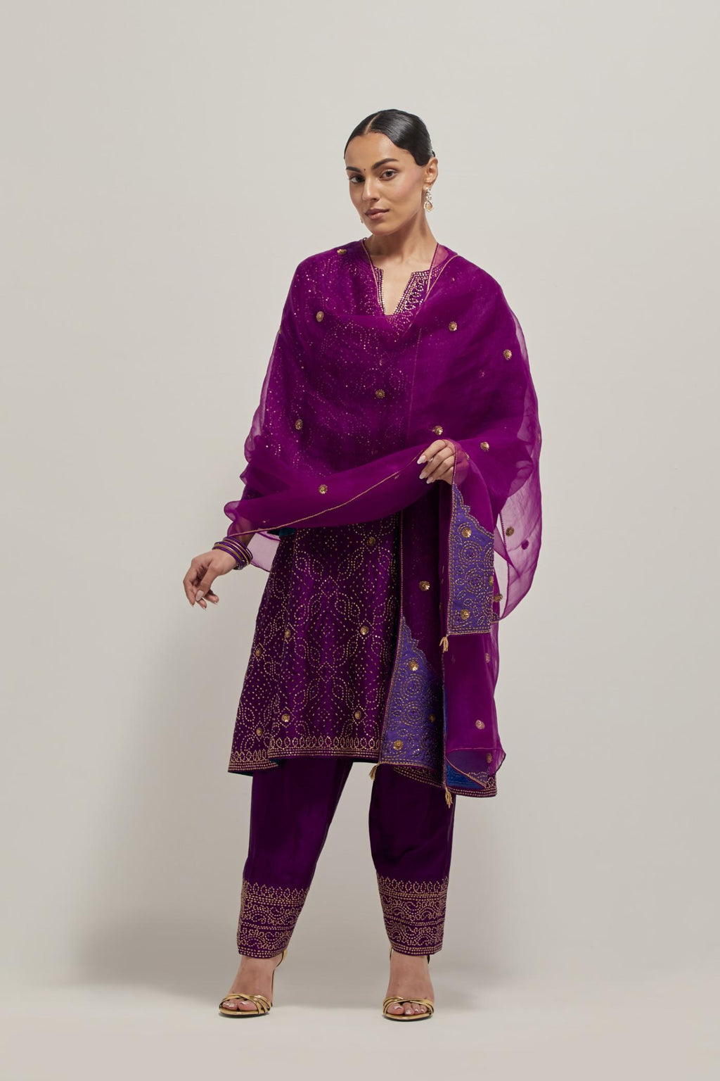 Purple silk A-line kurta set with hand embroidered sequins on bandhani inspired jaal all-over the kurta, highlighted with contrast-colored beads.