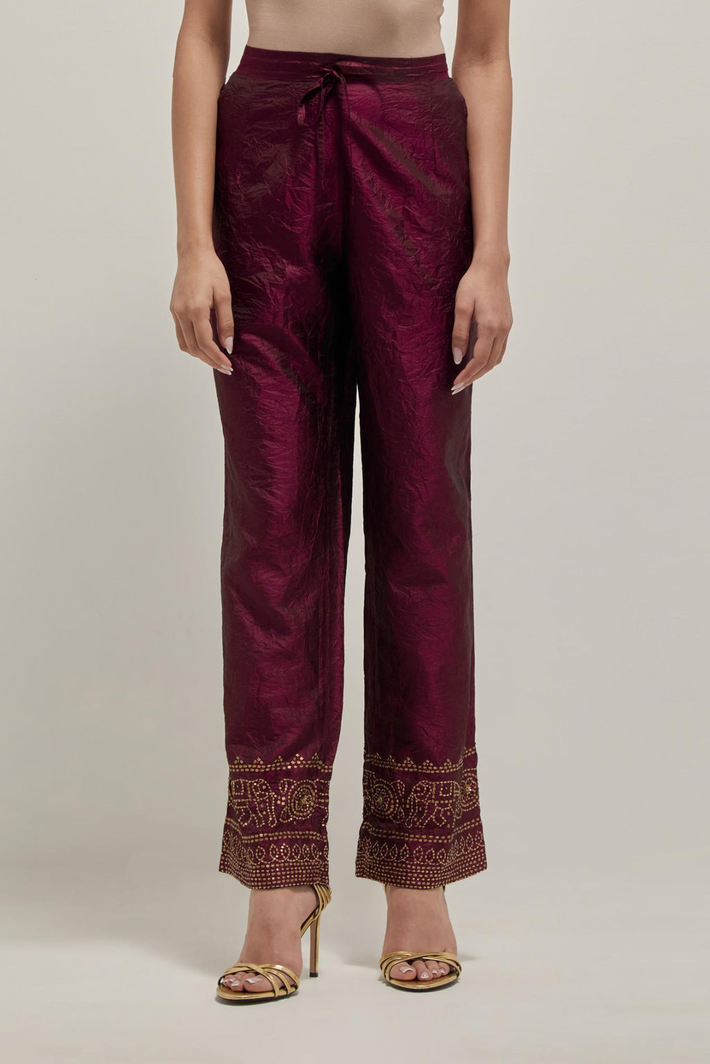 Maroon silk pants with a broad bandhani-inspired border at the hem, detailed with delicate bead and sequin work.