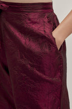 Maroon silk pants with a broad bandhani-inspired border at the hem, detailed with delicate bead and sequin work.