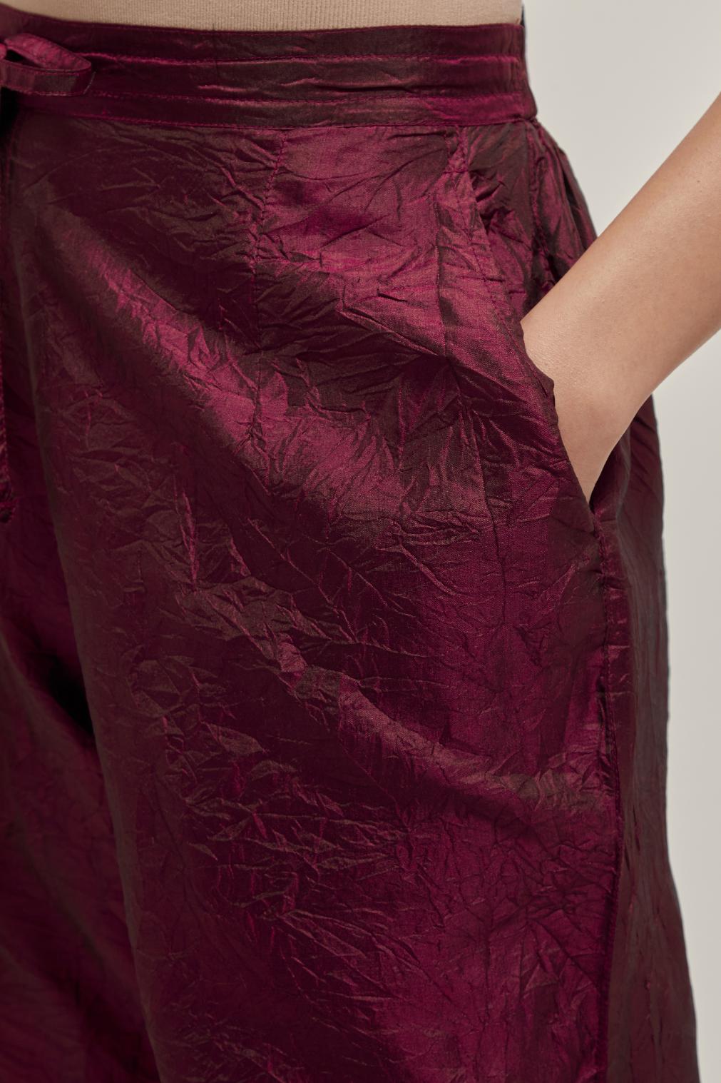 Maroon silk pants with a broad bandhani-inspired border at the hem, detailed with delicate bead and sequin work.