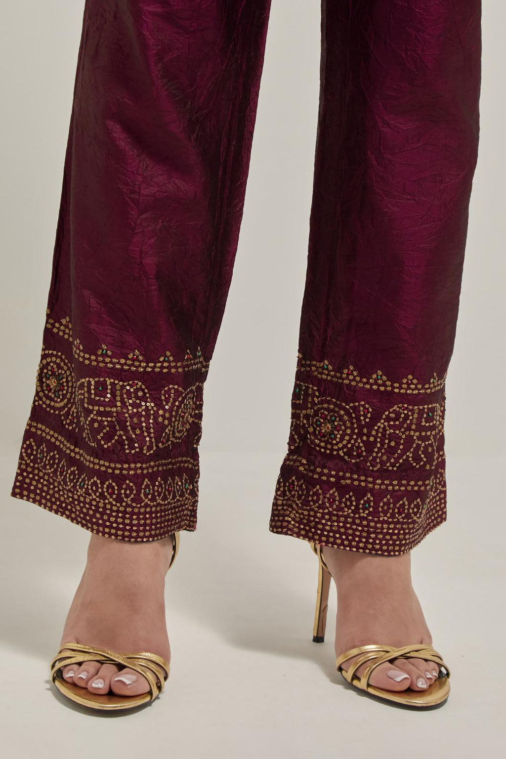 Maroon silk pants with a broad bandhani-inspired border at the hem, detailed with delicate bead and sequin work.