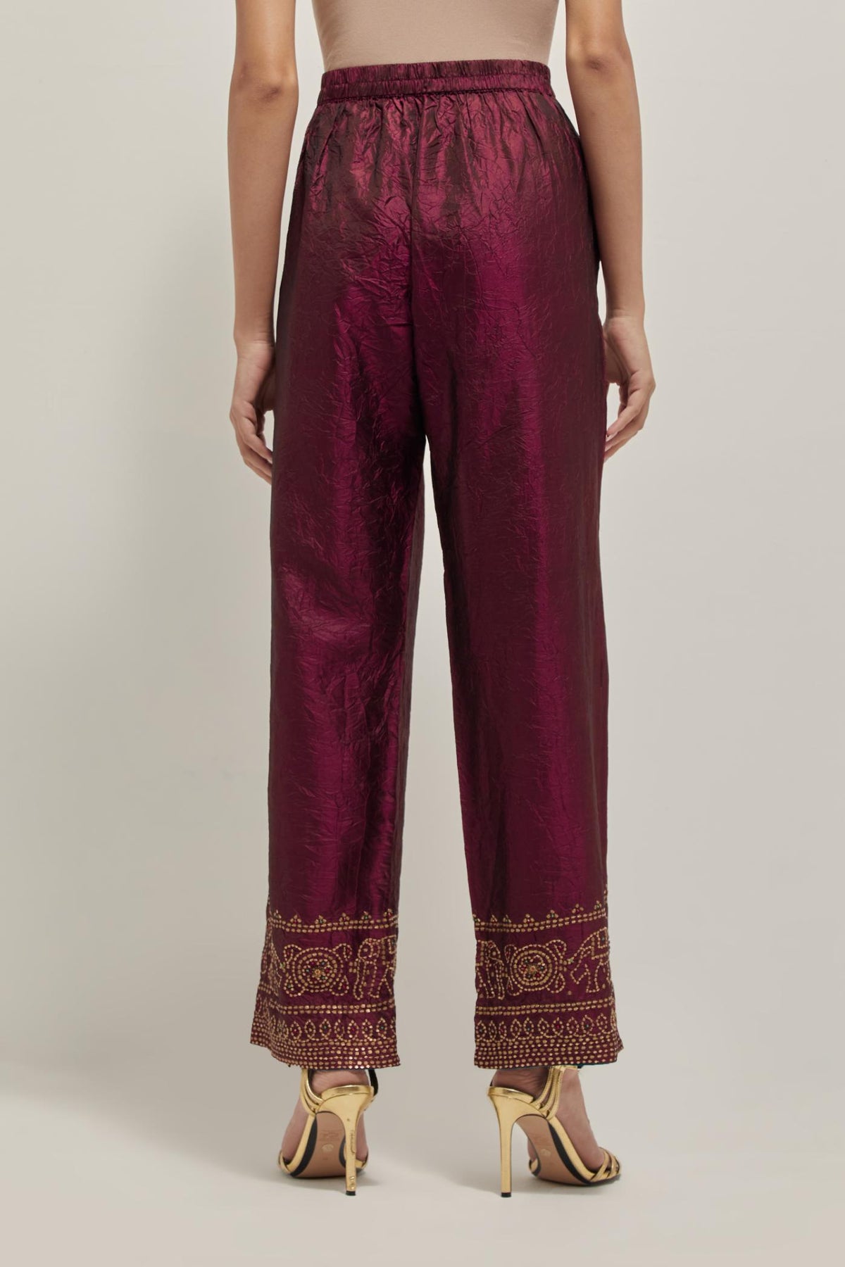 Maroon silk pants with a broad bandhani-inspired border at the hem, detailed with delicate bead and sequin work.